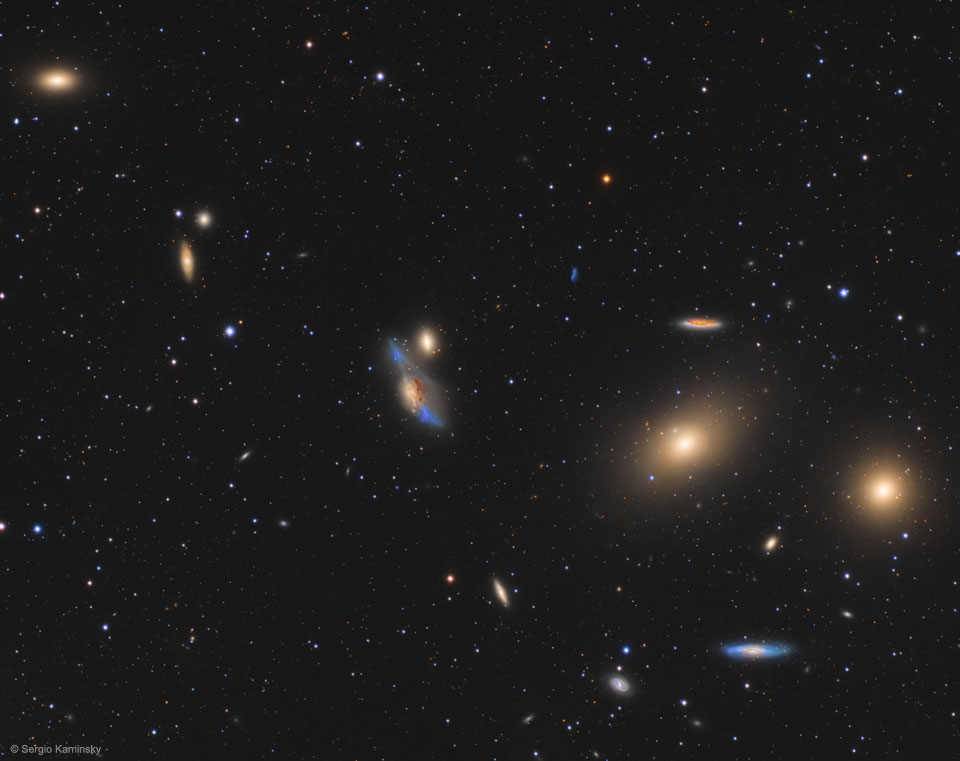 Im Bild voll Sternen und Galaxien verläuft diagonal durchs bild eine Kette aus sehr markenten Galaxien.