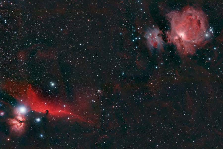Links unten leuchtet der Flammennebel und ein roter Nebel mit einer pferdekopfförmigen Silhouette, rechts oben ist der Orionnebel.