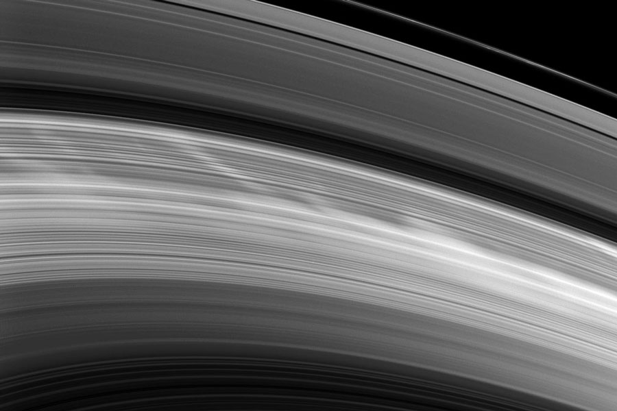 Der gezeigte Ausschnitt der fein gerillten Saturnringe ist von quer gestellten hellen Speichen überzogen.