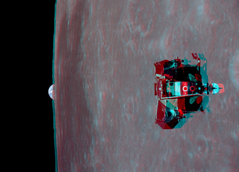 Das Stereobild in Rot und Cyan zeigt das Mondlandemodul vor dem riesigen Mond, links am Rand taucht die Erde auf.