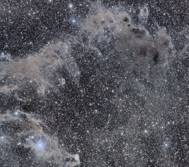Das schwarzweiß wirkende Bild sind Wolken über einen Hintergrund mit Sternen verteilt.