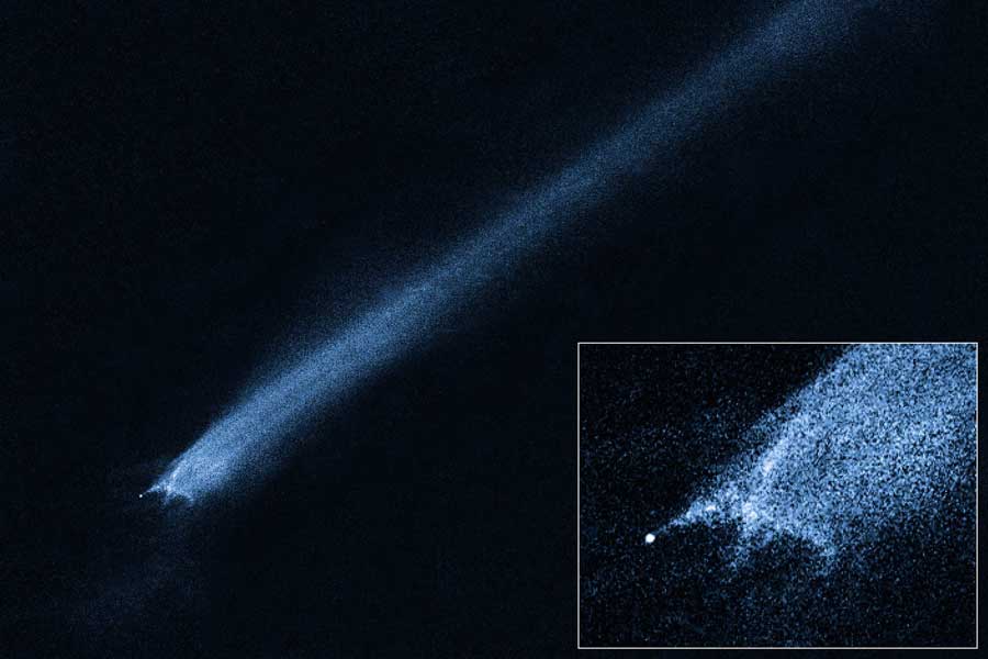 Das Bild zeigt einen Kometenschweif, der von links unten diagonal sehr gerade nach rechts oben verläuft. Rechts unten ist ein Einschub, der den Kometenkopf detailreich zeigt.