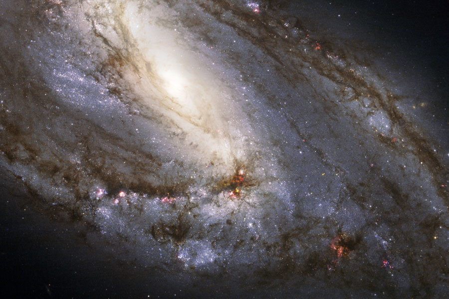 Der rechte untere Teil der Spiralgalaxie M66 ist bildfüllend dargestellt. Oben ist das helle Zentrum, nach unten breiten sich die Spiralarme mit Staubbahnen aus. Die Galaxie ist schräg von oben zu sehen.