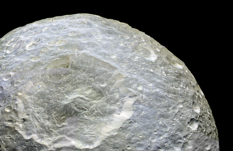 Das Bild zeigt einen Teil des Mondes Mimas, er ist links und unten angeschnitten. Die Oberfläche ist stark verworfen, in der Mitte ist ein tiefer Einschlagkrater mit Zentralberg. Um diesen jungen Einschlag sind nur wenige Krater. Am hinteren Rand rechts sind mehr Krater zu sehen.