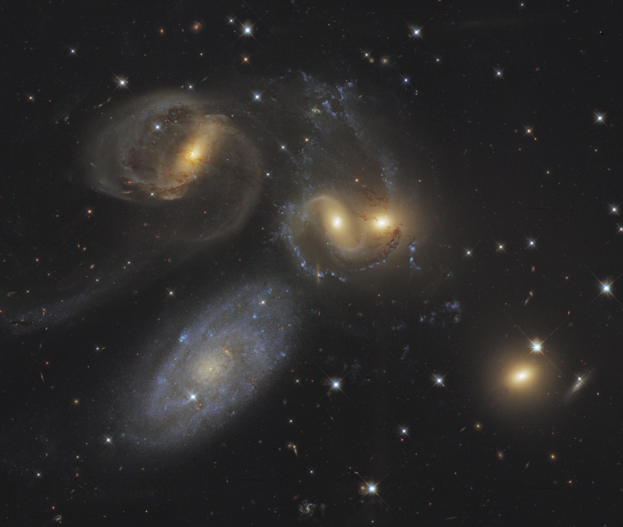 Von den fünf Galaxien im Bild gehören nur vier zu einer Gruppe. Sie sind von wenigen Sternen umgeben.