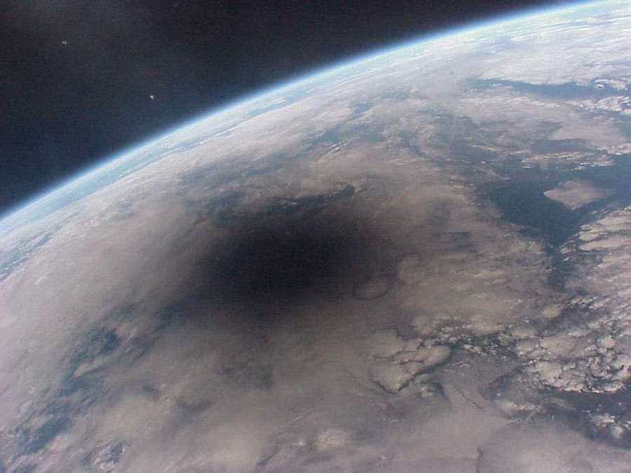 Die Erde vom Weltraum aus gesehen hat hier einen dunklen Fleck. Es ist der Mondschatten. Menschen im Schatten können zu dieser Zeit eine Sonnenfinsternis sehen.