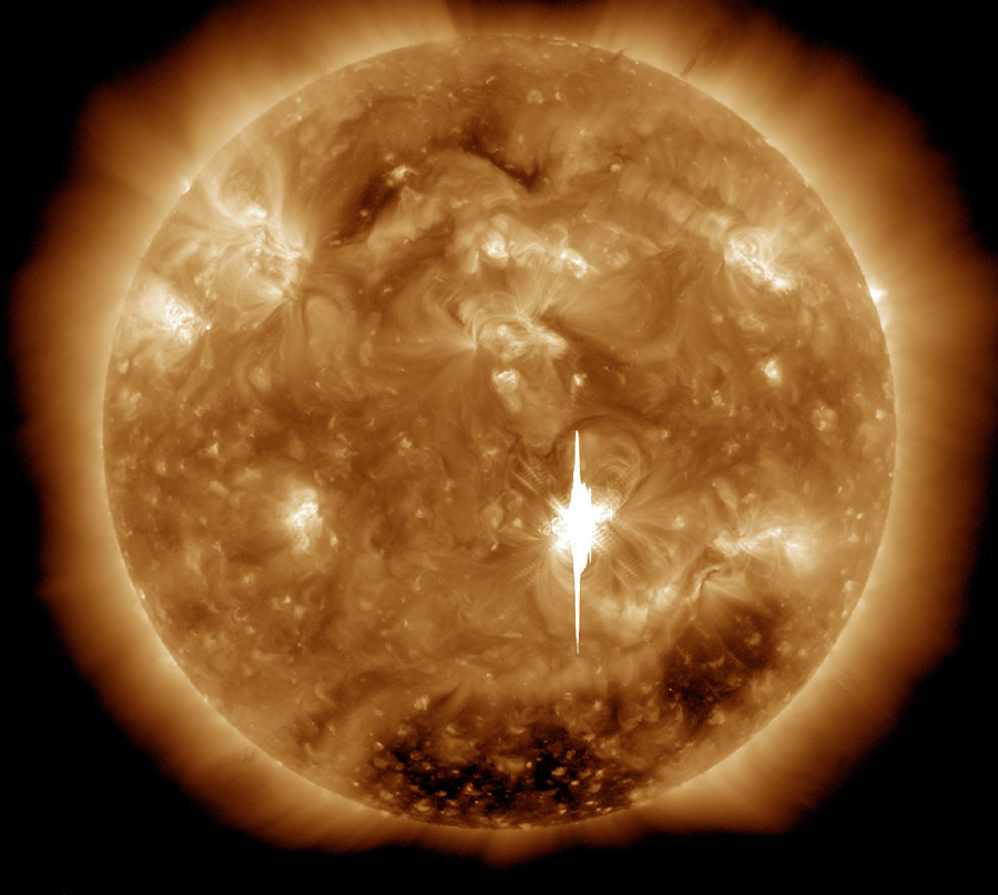 Die Sonne ist bildfüllend dargestellt, außen leuchtet die Korona, auf der Oberfläche leuchten einige helle Stellen mit wolkigen Schlieren dazwischen, in der Mitte ist ein weißer Fleck, der so hell leuchtet, dass die Bildpunkte des Sensors rundum überbelichtet sind.