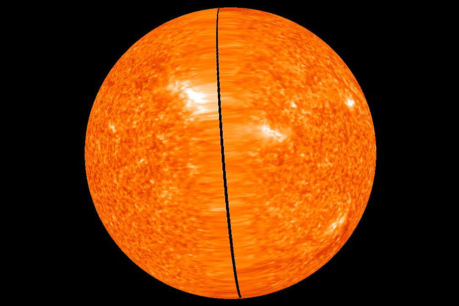 Die orange Kugel der Sonne ist zweigeteilt. Vorne läuft eine schwarze Linie über die Oberfläche, links und rechts davon wirkt die Granulation stark in die Länge gezogen.