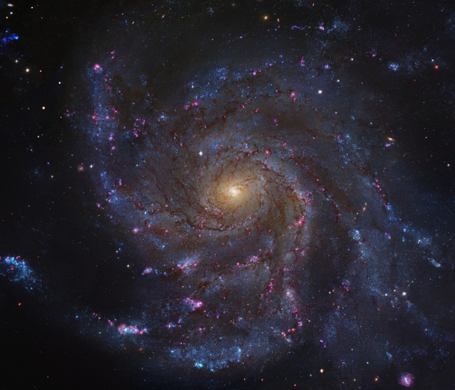 Die Spiralgalaxie im Bild hat sehr lose gewundene Spiralarme. Das Zentrum in der Mitte leuchtet gelb und ist eher klein. Wir sehen die Galaxie von oben.