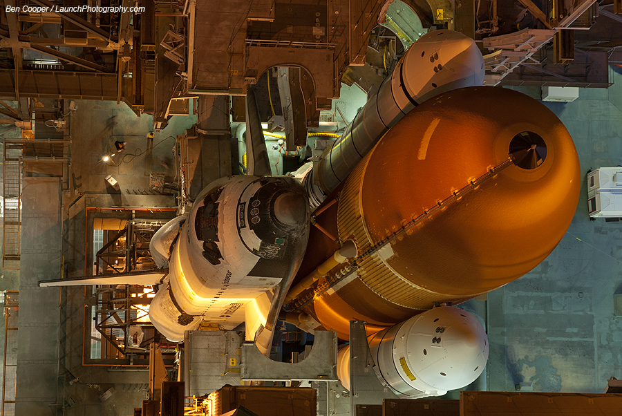 Die Raumfähre Endeavour ist von oben zu sehen, sie hängt am riesigen orangefarbenen Treibstofftank. An den Seiten des Tanks sind die Feststoffbooster befestigt.