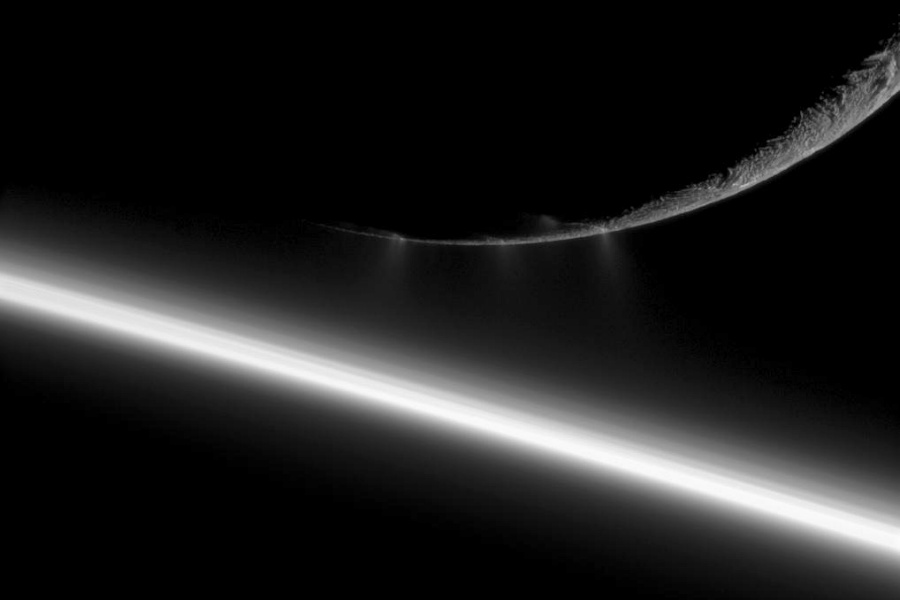 Links unten verläuft ein sehr heller Streifen schräg durchs Bild, es ist der Rand von Saturn. Rechts oben ist der unterste Teil einer beleuchteten Sichel eines Himmelskörpers zu sehen.