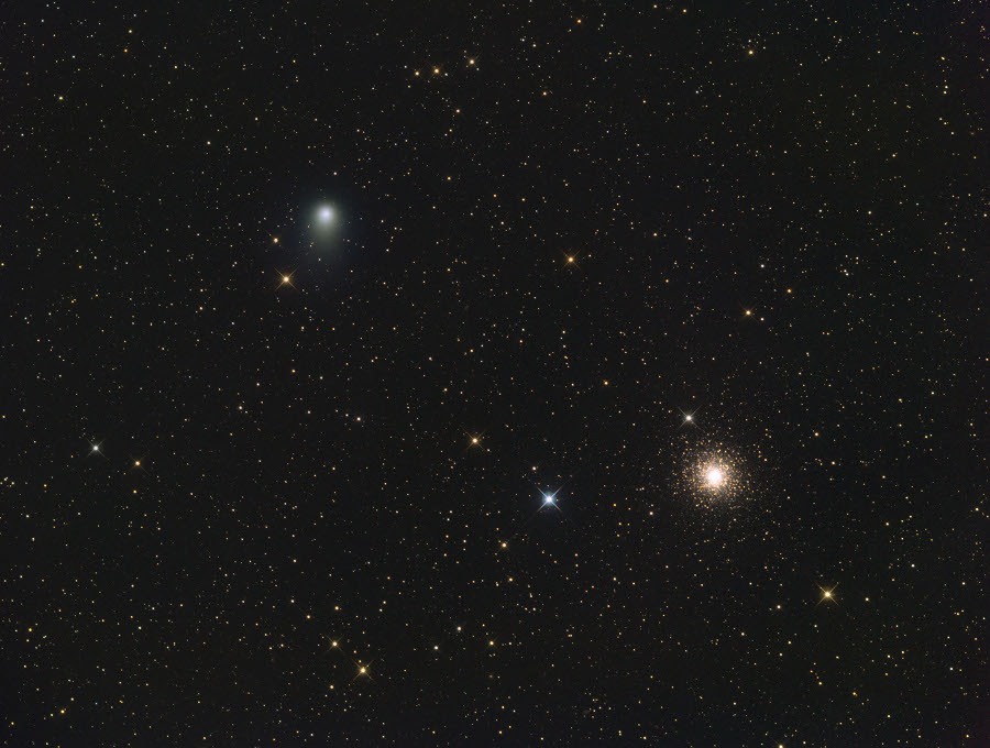 Zwei helle Lichtflecke sind im Bild das von vielen schwachen und einigen hellen Sternen übersät ist: Links oben der Komet Garrad mit blassem Schweif, rechts unten ein Kugelsternhaufen.