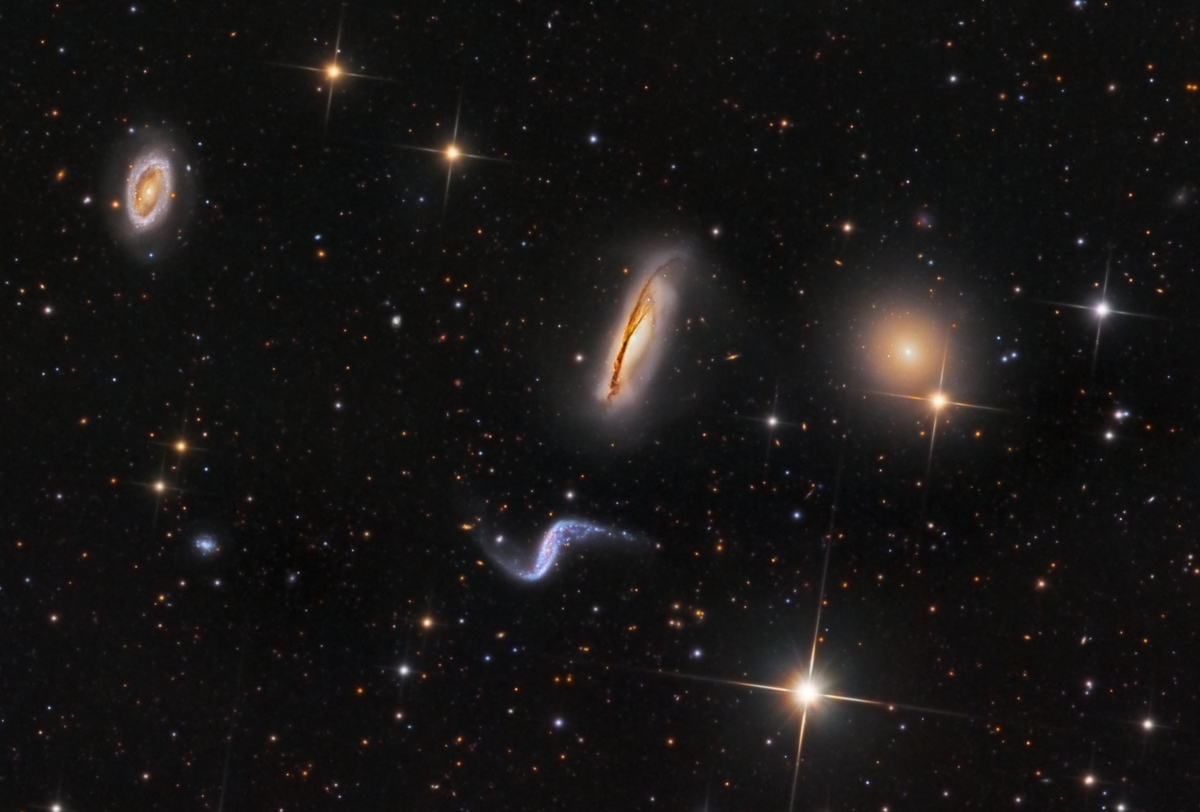 Im Bild sind mehrere Galaxien verteilt, die sich stark voneinander unterscheiden.