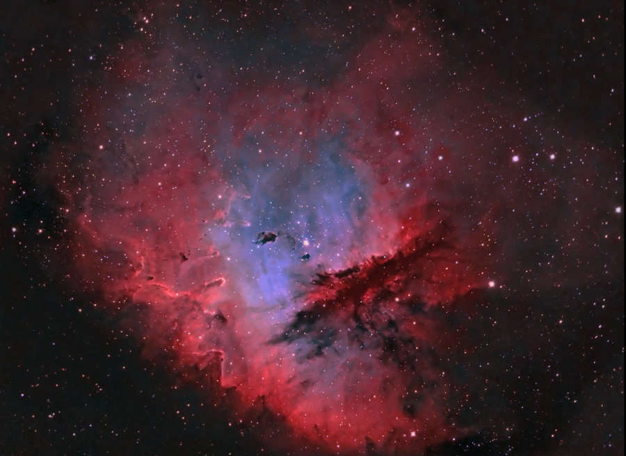 Eine rote, leicht ausgefranste Wolke mit vielen dichten Knoten leuchtet im Inneren ultramarinblau.