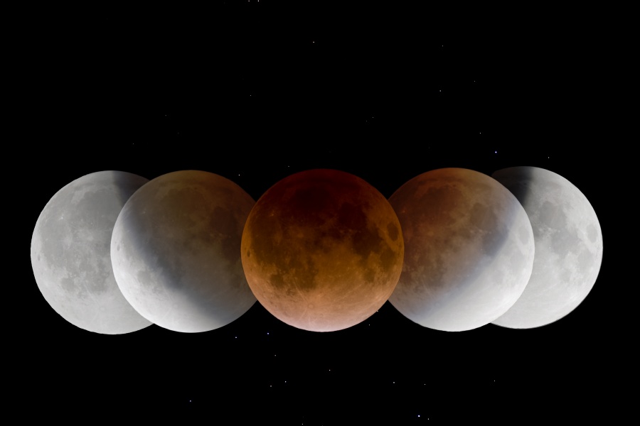 Fünf Abbildungen zeigen die Wanderung des Mondes am Himmel durch den Kernschatten der Erde bei einer partiellen Mondfinsternis. Der Kernschatten ist innen rötlich gefärbt. Auf dem Mond sind die dunklen Meere gut erkennbar.