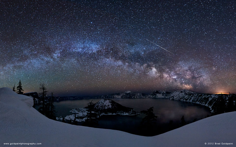 Über einem Kratersee, dem Crater Lake in Oregon, wölbt sich die Milchstraße, davor blitzen Meteore über den Himmel. Wenn man den Mauspfeil über das Bild schiebt, werden die Sternbilder eingeblendet.