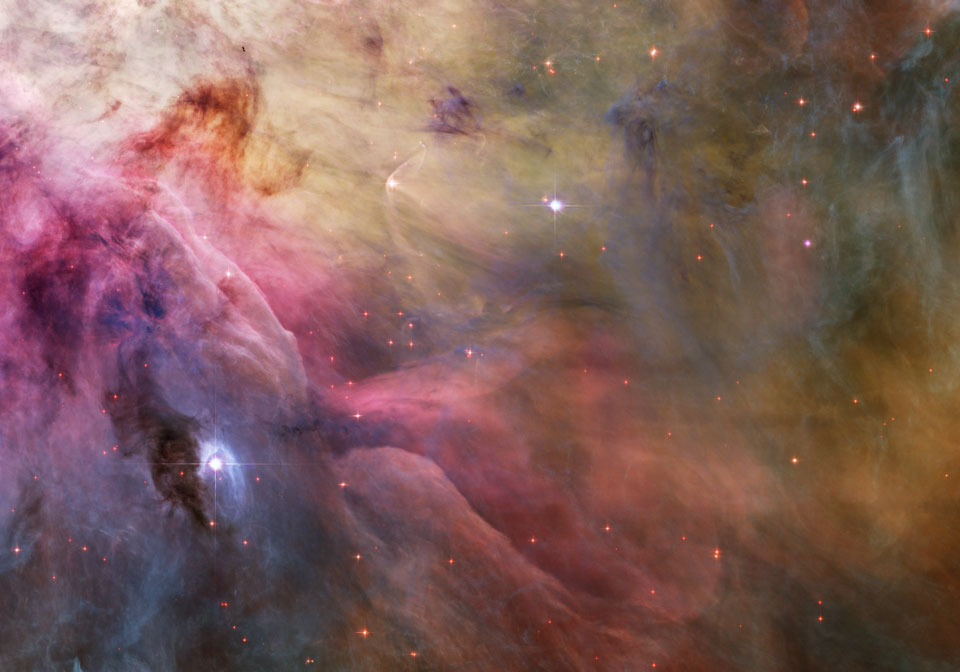 Das Bild ist mit verwehten Nebeln gefüllt, links unten leuchtet der Nebel violett und rosarot, rechts oben gelb. Mitten im Bild ist ein Stern mit Bugwelle.