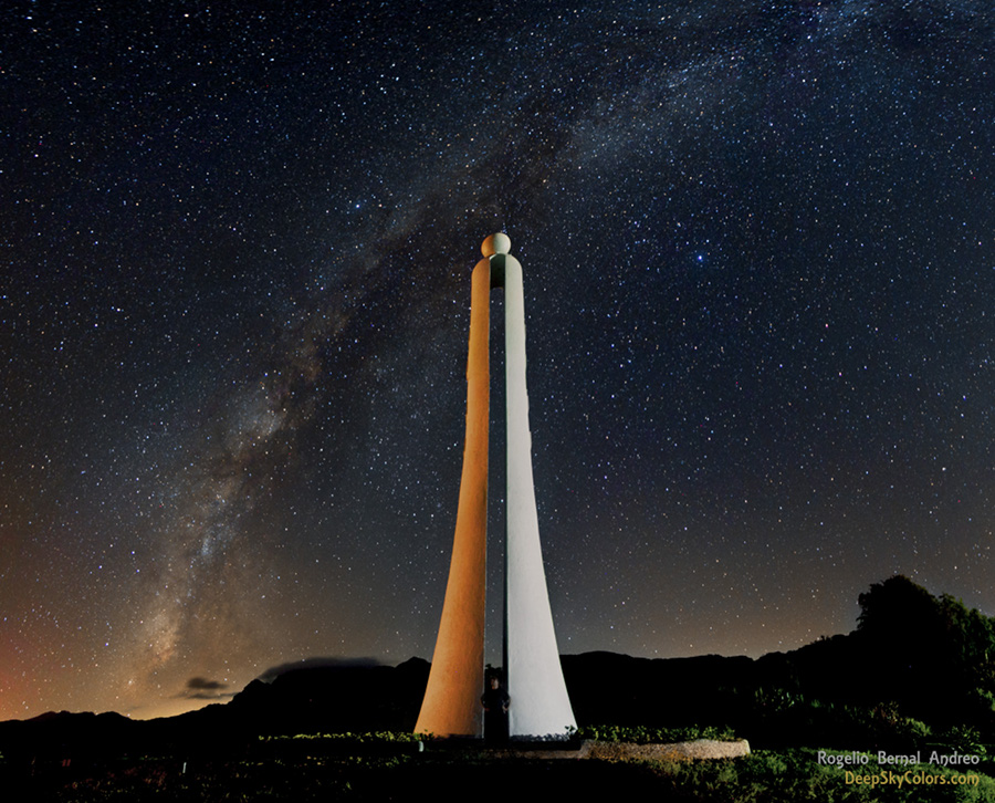 Vor einem Nachthimmel mit Milchstraße ragt eine gespaltene Säule hoch, an deren Spitze eine Kugel ist.