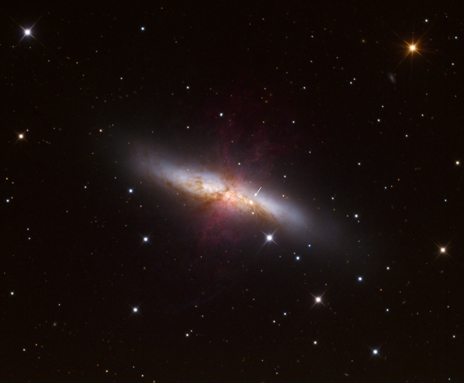 Eine irreguläre Galaxie mitten im Bild ist von wenigen markanten Sternen umgeben.