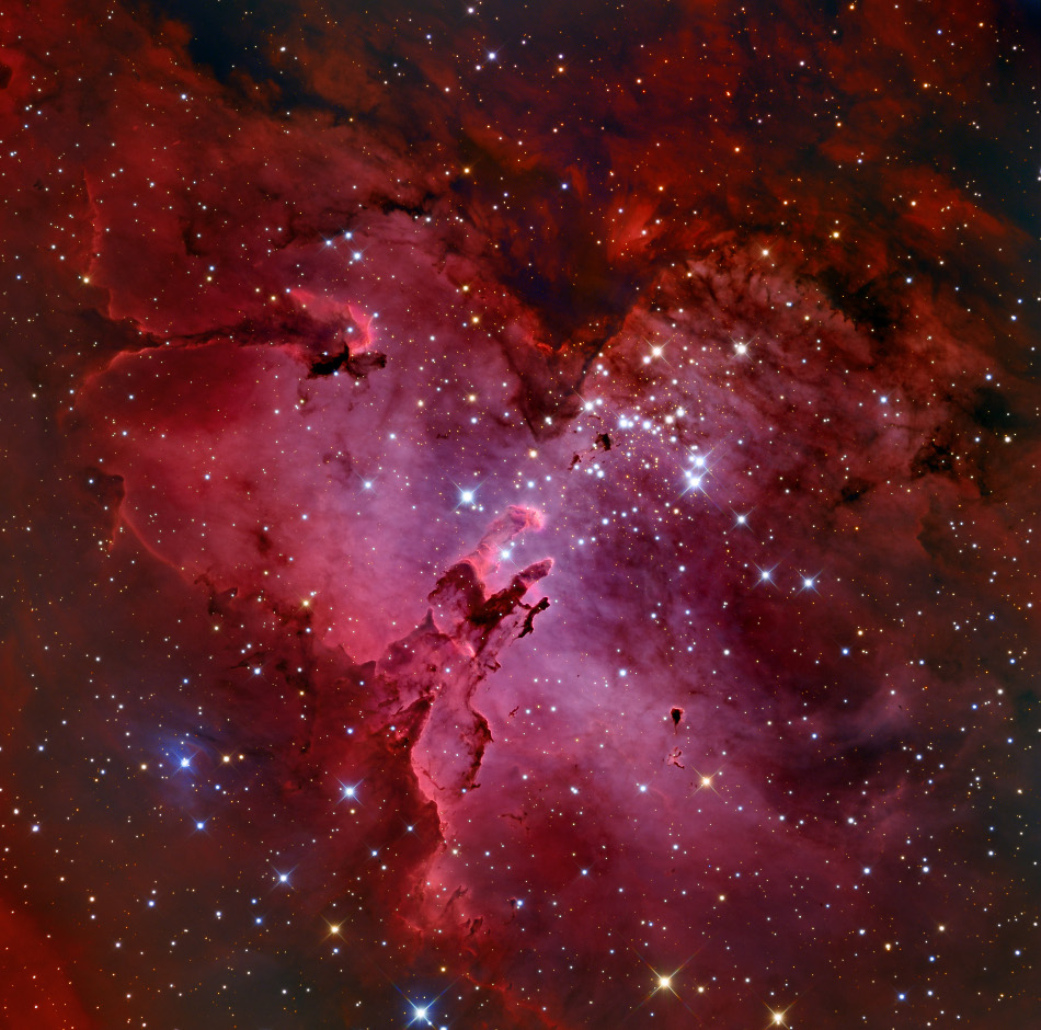 Der bildfüllende rote Nebel enthält viele wesenhafte Staubwolken, die auf Hubble-Aufnahmen berühmt wurden, sowie einen offenen Sternhaufen.