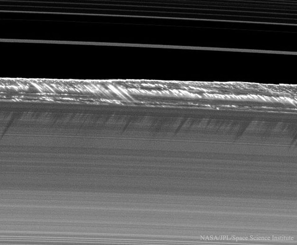 Der obere Rand der Saturnringe, deren Struktur an eine Schallplatte erinnert, ist von Erhebungen gesäumt, die mehrere Kilometer hoch sein müssen. Diese Erhebungen werfen Schatten auf die Ringe.