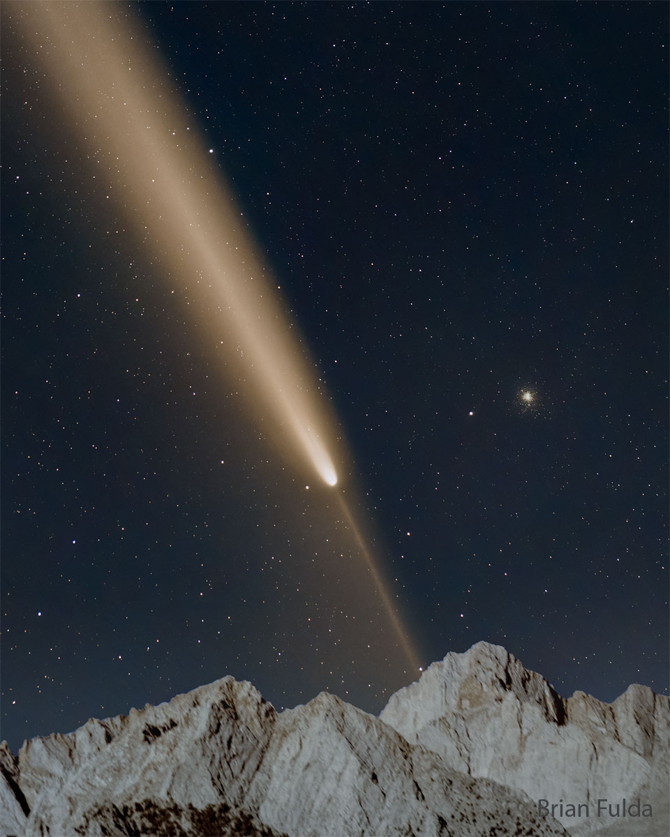 Über einem Gebirge ragt ein sternklarer Himmel auf. Bildfüllend sind der Kopf und der ausladende Schweif des Kometen C/2023 A3 Tsuchinshan-ATLAS dargestellt, rechts daneben ist der Kugelsternhaufen M5 hingesprenkelt.