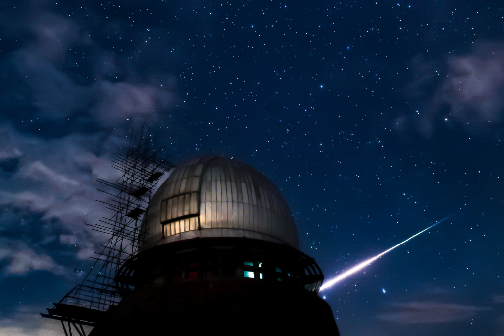 Hinter der Kuppel der Xuyi-Station des Purple-Mountain-Observatoriums (Tsuchinshan) leuchtet eine helle Feuerkugel auf. Das Bild wurde während des Meteorstroms der Perseïden fotografiert.