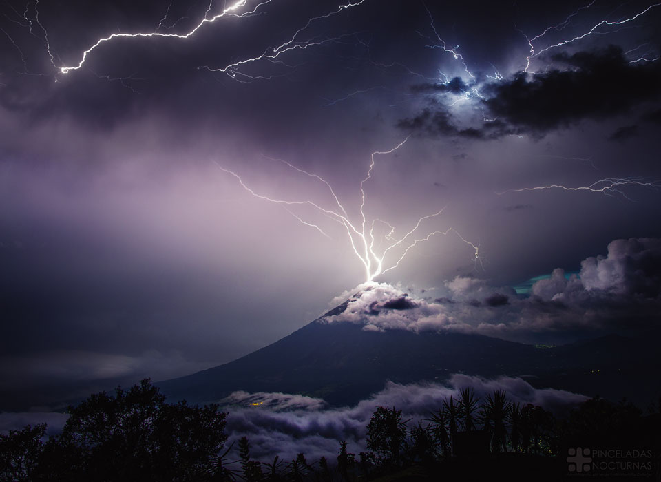 Aus dem Gipfel des Vulkans Volcán de Agua in Guatemala sprengt ein Büschel Blitze nach oben in die dunklen Wolken.
