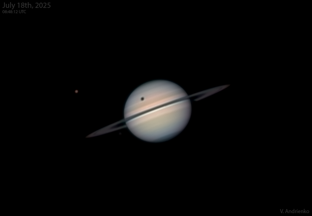 Der Planet Saturn mit schmalen, dunklen Ringen liegt mitten im Bild. Oben hat er einen schwarzen Fleck, es ist der Schatten des Mondes Titan, der links über dem Planeten steht.