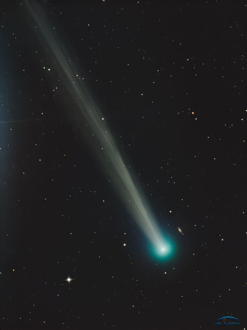 Der Kopf des Kometen C/2025 R2 (SWAN) ist rechts unten, er ist von einer hellgrünen Koma umgeben. Nach links oben breitet sich der gefaserte Schweif aus. Im Hintergrund sind Sterne verteilt.