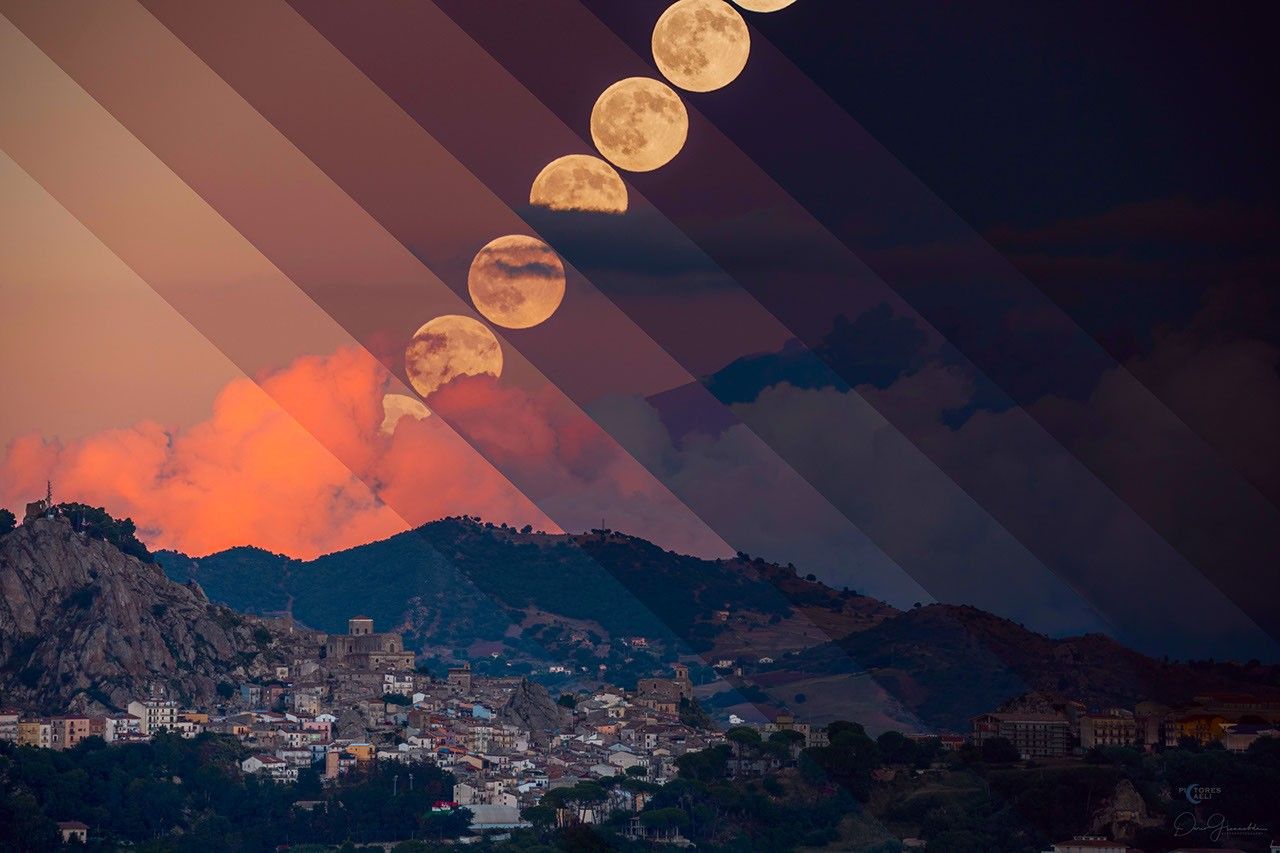 Über der italienischen Stadt Nikosia auf der Insel Sizilien geht der Vollmond auf. Der rot beleuchtete Rauch über dem Horizont steigt aus dem Ätna auf. Nach rechts wird der Himmel auf dem zusammengesetzten Bild immer dunkler.